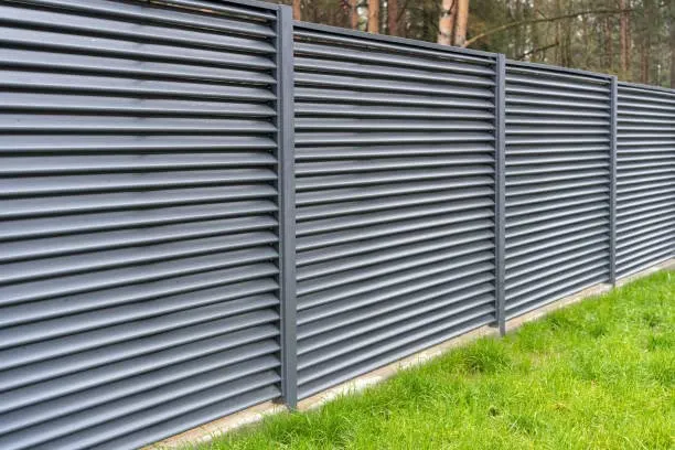 Dark horizontal slat fence beside a lawn